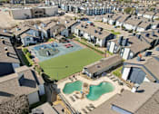 Thumbnail 35 of 40 - A bird's eye view of a neighborhood with a large swimming pool in the foreground.
