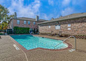 Thumbnail 16 of 22 - A pool surrounded by a brick wall and a bench.