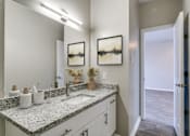 Thumbnail 9 of 22 - A bathroom with a granite countertop and two sinks.