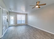 Thumbnail 6 of 22 - A room with a ceiling fan and wooden flooring.