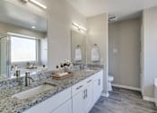 Thumbnail 14 of 22 - A bathroom with two sinks and a large mirror.