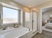 Thumbnail 13 of 22 - A white bathroom with a tub, sink, and window.