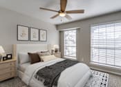 Thumbnail 5 of 22 - A bedroom with a large bed and a ceiling fan.