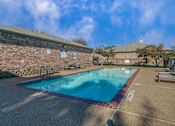 Thumbnail 15 of 22 - A large outdoor swimming pool surrounded by a brick wall.