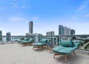 Thumbnail 20 of 66 - an outdoor terrace with lounge chairs and a view of the city