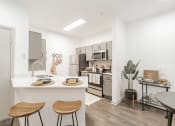 Thumbnail 1 of 20 - a kitchen with a breakfast bar and stools and a large kitchen with stainless steel