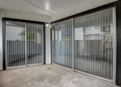 Thumbnail 14 of 36 - a patio with two sliding glass doors and a tree in the background