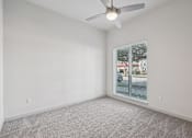 Thumbnail 29 of 57 - A room with a ceiling fan and carpeted floor.