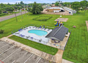 Thumbnail 13 of 27 - A pool with a slide and a building in the background.