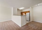 Thumbnail 5 of 30 - A kitchen area with a refrigerator, cabinets, and a countertop.