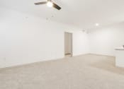 Thumbnail 6 of 41 - an empty living room with white walls and a ceiling fan