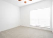 Thumbnail 18 of 33 - an empty room with a window and a ceiling fan