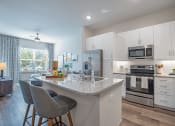 Thumbnail 1 of 22 - a kitchen with white cabinets and a marble counter top