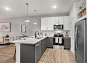 Thumbnail 3 of 47 - A modern kitchen with a large island and stainless steel appliances.