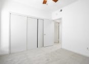 Thumbnail 19 of 33 - an empty room with white walls and white closet doors