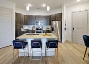 Thumbnail 5 of 36 - a kitchen with a marble counter top with blue chairs