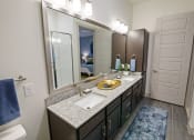 Thumbnail 14 of 36 - a bathroom with granite countertops and a large mirror