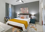 Thumbnail 10 of 36 - a bedroom with a bed and a ceiling fan