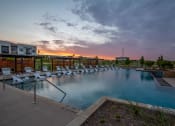 Thumbnail 35 of 36 - a swimming pool with lounge chairs at sunset at the grove resort and spa