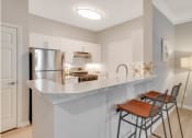 Thumbnail 13 of 17 - a kitchen with a counter top and a stainless steel refrigerator