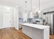 Thumbnail 31 of 38 - A modern kitchen with a large island and stainless steel appliances.