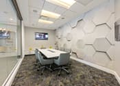 Thumbnail 28 of 44 - a conference room with a table and chairs and a tv on the wall