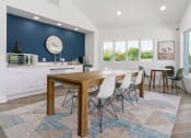 Thumbnail 14 of 29 - a dining room with a table and chairs and a clock on the wall