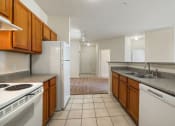 Thumbnail 4 of 30 - A kitchen with white appliances and brown cabinets.