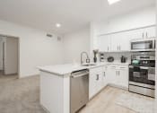 Thumbnail 13 of 41 - a white kitchen with an island and stainless steel appliances