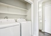 Thumbnail 17 of 17 - A white laundry room with a washer and dryer.