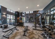 Thumbnail 23 of 30 - a spacious fitness center with cardio machines and weights