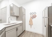 Thumbnail 2 of 20 - a kitchen with white cabinets and stainless steel appliances and a stainless steel refrigerator