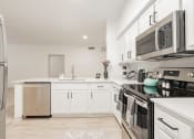 Thumbnail 9 of 41 - a renovated kitchen with white cabinets and stainless steel appliances