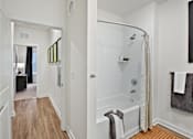 Thumbnail 13 of 47 - A white bathroom with a walk in shower and a towel hanging on the side.