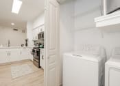 Thumbnail 39 of 41 - a laundry room with a washer and dryer and a kitchen with white appliances