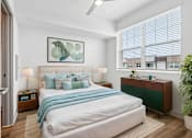 Thumbnail 9 of 34 - A bedroom with a large bed and a ceiling fan.