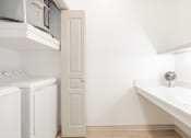 Thumbnail 16 of 41 - a laundry room with a washer and dryer and a window and a sink
