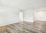 Thumbnail 11 of 21 - A room with a white wall and a wooden floor.