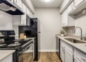 Thumbnail 2 of 20 - a kitchen with white cabinets and black appliances and a sink