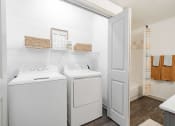 Thumbnail 10 of 20 - a washer and dryer in a laundry room with a door to the bathroom