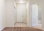 Thumbnail 2 of 30 - A hallway with a brown rug and white doors.