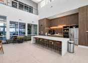 Thumbnail 4 of 31 - A modern kitchen with a bar area and a view of the city.