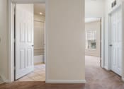 Thumbnail 8 of 30 - A hallway with white doors and a brown carpet.