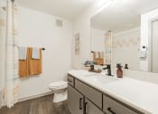 Thumbnail 9 of 20 - a bathroom with a large mirror and a sink and a toilet