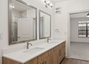 Thumbnail 27 of 33 - A bathroom with a white sink and mirrors.
