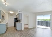 Thumbnail 6 of 19 - an open kitchen and living room with a sliding glass door to a balcony