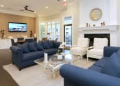 Thumbnail 3 of 17 - a living room with blue couches and chairs and a fireplace