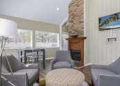 Thumbnail 15 of 16 - a living room with a fireplace and a table and chairs
