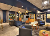 Thumbnail 14 of 17 - a lounge area with blue walls and orange chairs and blue couches
