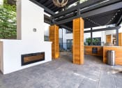 Thumbnail 24 of 37 - an outdoor kitchen with a fireplace and a bar